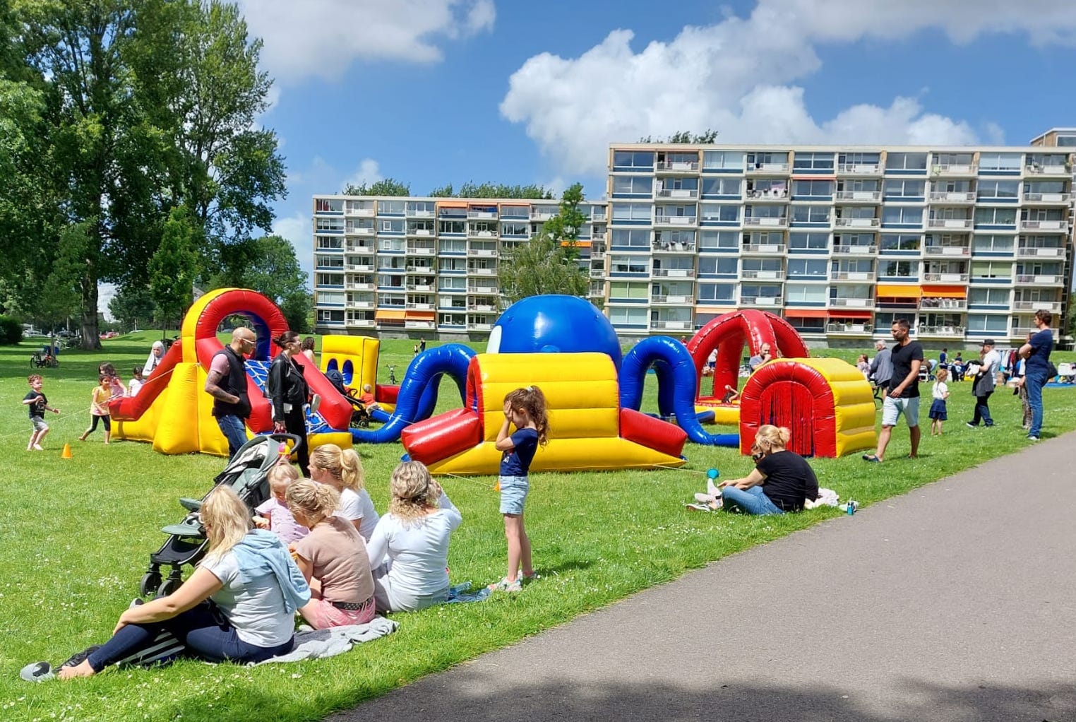 "Foto van een springkussen en mensen in het gras"