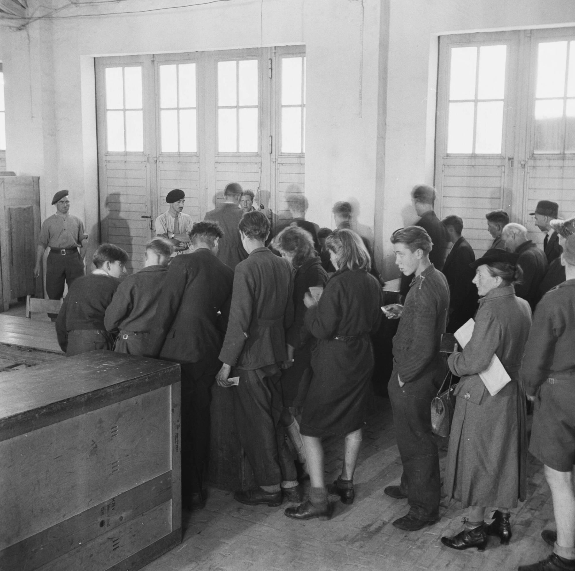 Repatrianten staan in een rij om zich te laten registreren in Rheine zomer 1945.