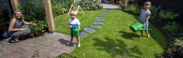 Lotte met de twee kinderen in hun nieuwe achtertuin