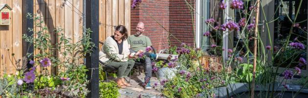 Roel en Bryony in hun tuin vol planten en bloemen